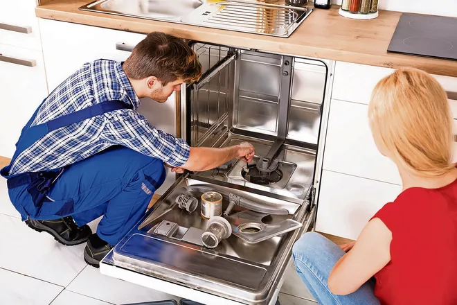 Technician repairing a dishwasher